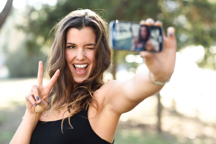 Frau, die ein Selfie mit ihrem Smartphone macht